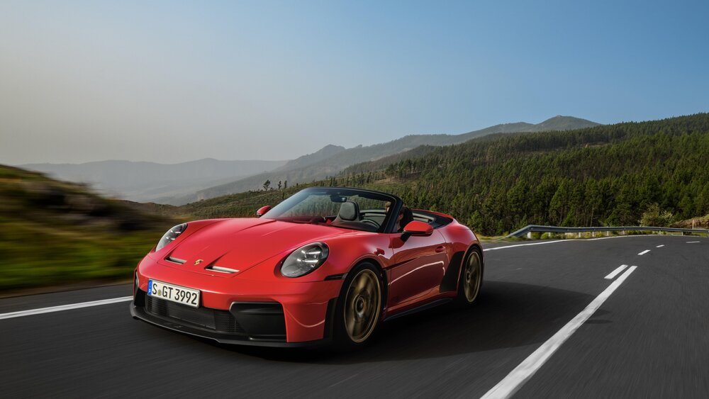 Porsche 911 GT3 S/C in Guards Red with the top down, driving on a mountain road