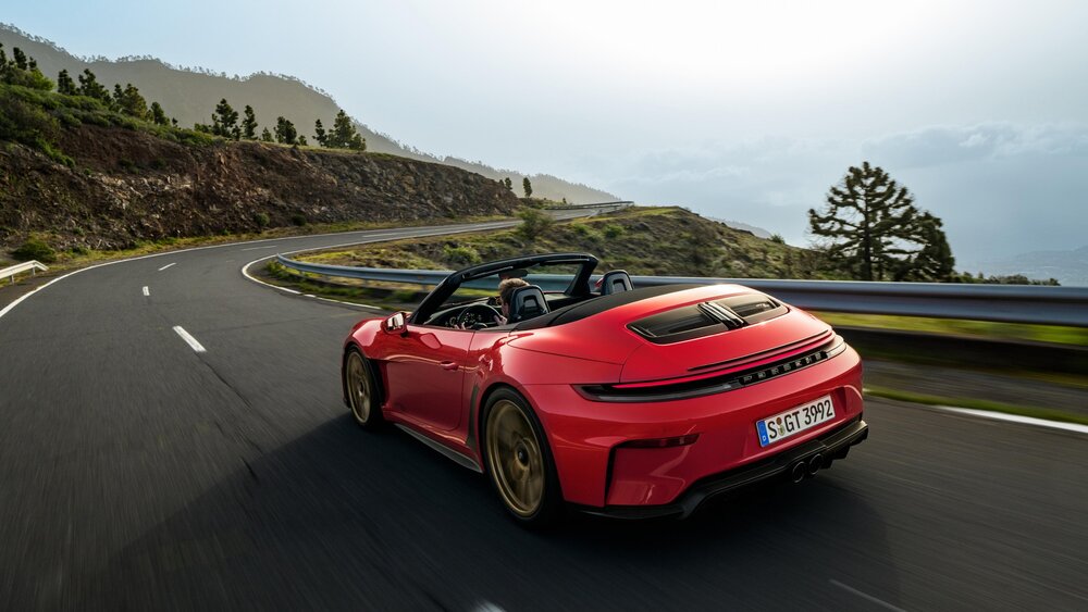 Rear three-quarter view of the GT3 S/C driving through mountain curves with the top down