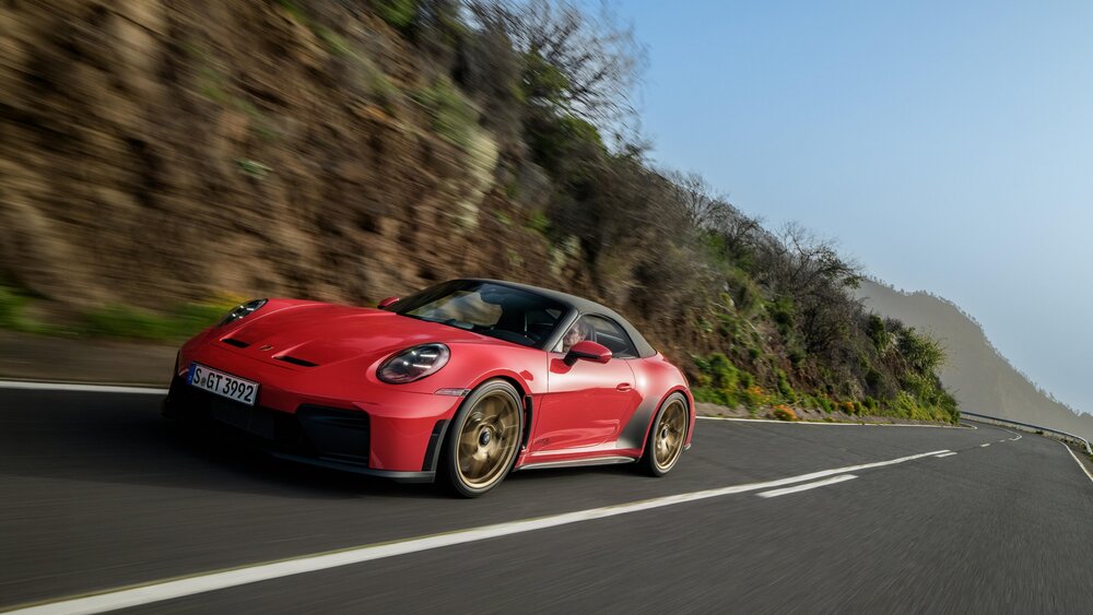 GT3 S/C in Guards Red driving with the roof up, showing the low cabriolet profile